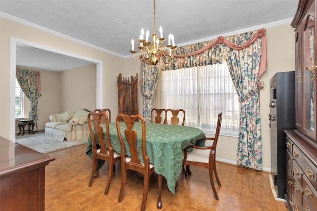 5934 Foresthaven Dr, Houston, TX 77066 - dining area with a chandelier, wood finished floors, crown molding, and a textured ceiling