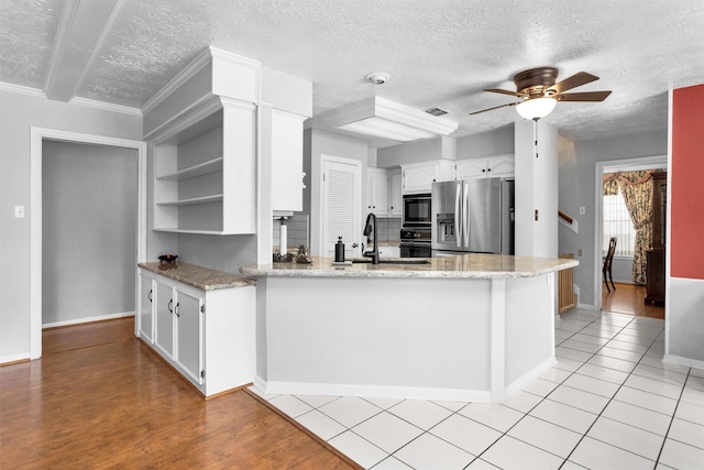 5934 Foresthaven Dr, Houston, TX 77066 - kitchen with a textured ceiling, black appliances, open shelves, a peninsula, and ceiling fan