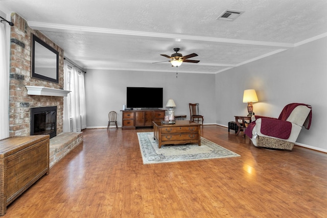 5934 Foresthaven Dr, Houston, TX 77066 - living room with a textured ceiling, wood finished floors, a brick fireplace, ceiling fan, and beam ceiling