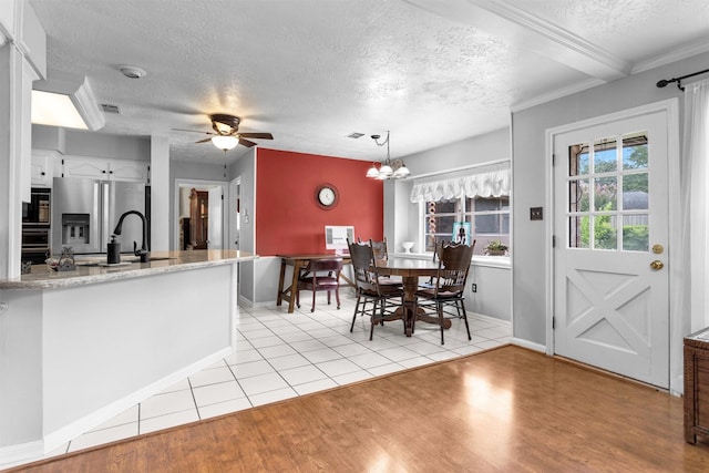 5934 Foresthaven Dr, Houston, TX 77066 - dining area featuring a textured ceiling, light wood-style flooring, ceiling fan, ornamental molding, and a chandelier