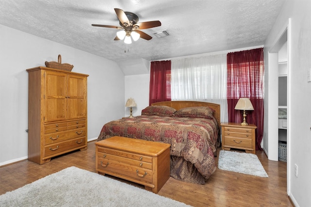 5934 Foresthaven Dr, Houston, TX 77066 - bedroom featuring a textured ceiling, wood finished floors, and a ceiling fan