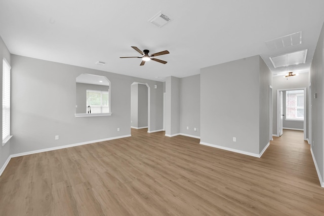 23911 Pinecreek Pt, Spring, TX 77373 - empty room with attic access, light wood-style floors, a ceiling fan, and arched walkways