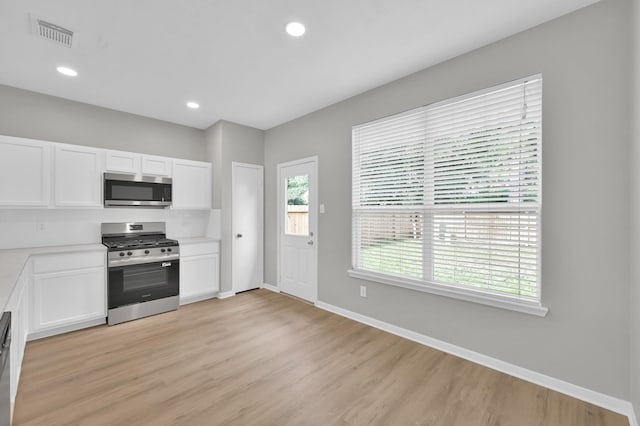 23911 Pinecreek Pt, Spring, TX 77373 - kitchen featuring stainless steel appliances, white cabinets, light countertops, light wood-style flooring, and recessed lighting