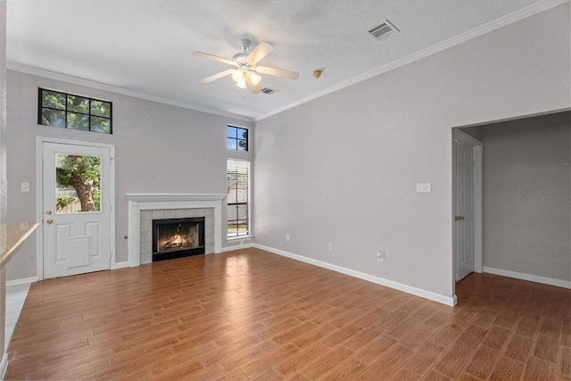 4303 Appalachian Trl, Houston, TX 77345 - unfurnished living room with ceiling fan, light wood-type flooring, a fireplace, and crown molding
