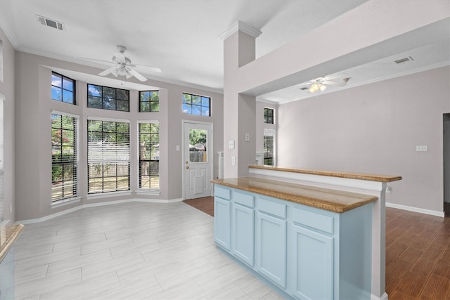 4303 Appalachian Trl, Houston, TX 77345 - kitchen featuring ceiling fan, crown molding, open floor plan, a center island, and light wood-type flooring