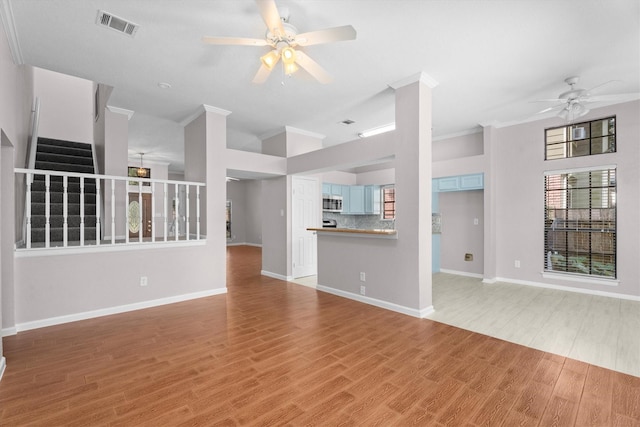 4303 Appalachian Trl, Houston, TX 77345 - unfurnished living room featuring a ceiling fan, light wood finished floors, crown molding, and stairway