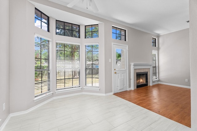 4303 Appalachian Trl, Houston, TX 77345 - unfurnished living room featuring healthy amount of natural light, a ceiling fan, crown molding, and a tile fireplace