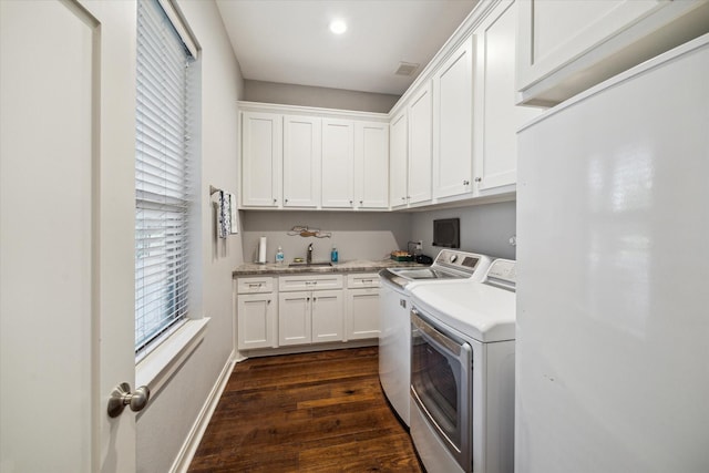 3848 S Main St, Anahuac, TX 77514 - washroom with washing machine and clothes dryer, cabinet space, and dark wood-style floors