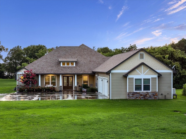 3848 S Main St, Anahuac, TX 77514 - rear view of property featuring french doors, a yard, stone siding, and a shingled roof