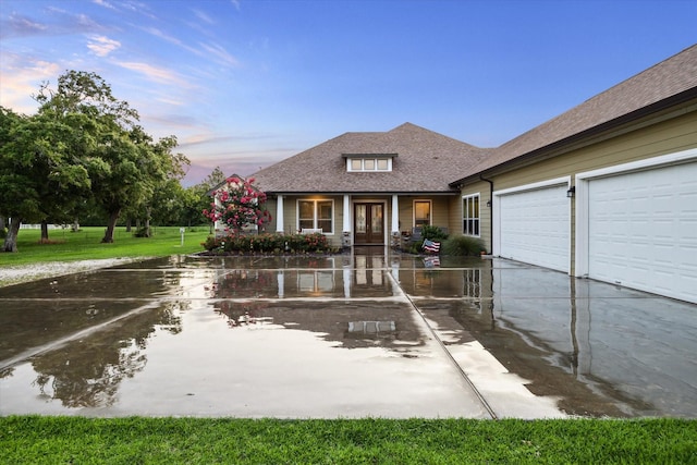 3848 S Main St, Anahuac, TX 77514 - view of front facade with concrete driveway, roof with shingles, an attached garage, and french doors
