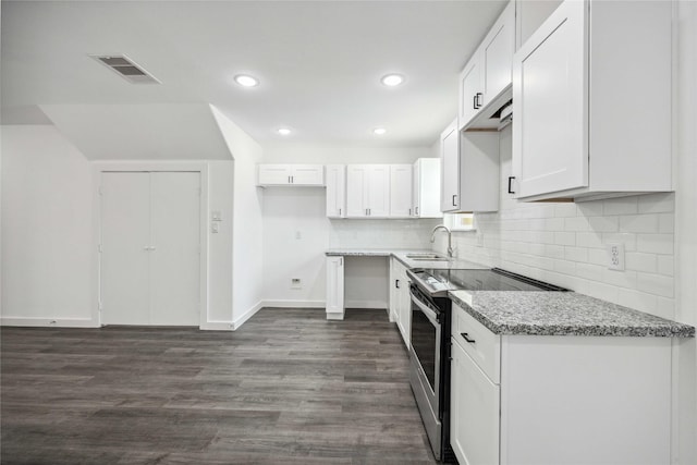2310 Wavell St, Houston, TX 77088 - kitchen with stainless steel electric range oven, light stone countertops, white cabinetry, backsplash, and dark wood-style floors