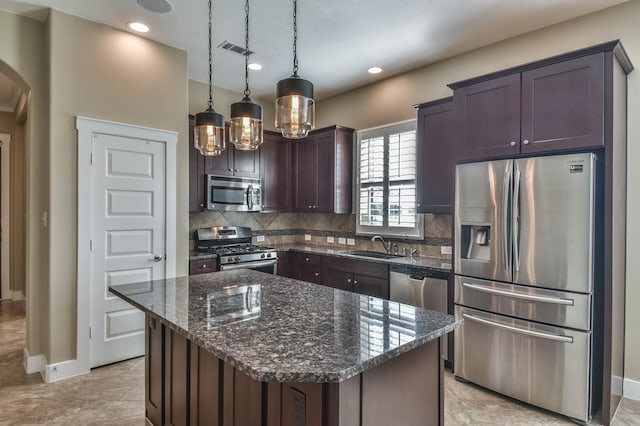 16803 Amelia Island Dr, Cypress, TX 77433 - kitchen with appliances with stainless steel finishes, arched walkways, backsplash, dark stone countertops, and dark brown cabinetry
