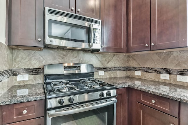 16803 Amelia Island Dr, Cypress, TX 77433 - kitchen with appliances with stainless steel finishes, backsplash, and dark stone countertops