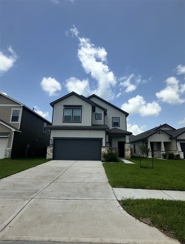 6414 Bolinas Ct, Rosharon, TX 77583 - view of front of property featuring stone siding, a garage, concrete driveway, a front lawn, and stucco siding