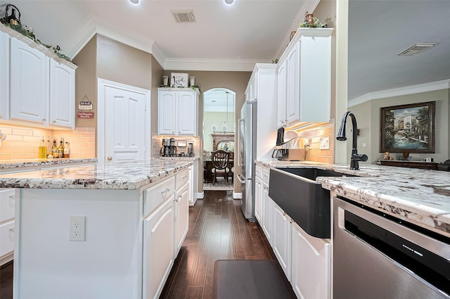9427 Fern Wood Frst, Houston, TX 77040 - kitchen featuring stainless steel appliances, crown molding, light stone counters, white cabinets, and tasteful backsplash