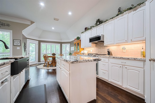 9427 Fern Wood Frst, Houston, TX 77040 - kitchen featuring a kitchen island, light stone counters, backsplash, white cabinets, and recessed lighting