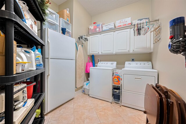 9427 Fern Wood Frst, Houston, TX 77040 - washroom featuring washer and dryer, light tile patterned flooring, and cabinet space