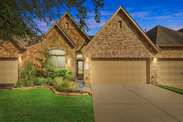 9707 Old Timber Ln, Spring, TX 77379 - french country style house with concrete driveway, brick siding, an attached garage, a lawn, and a shingled roof