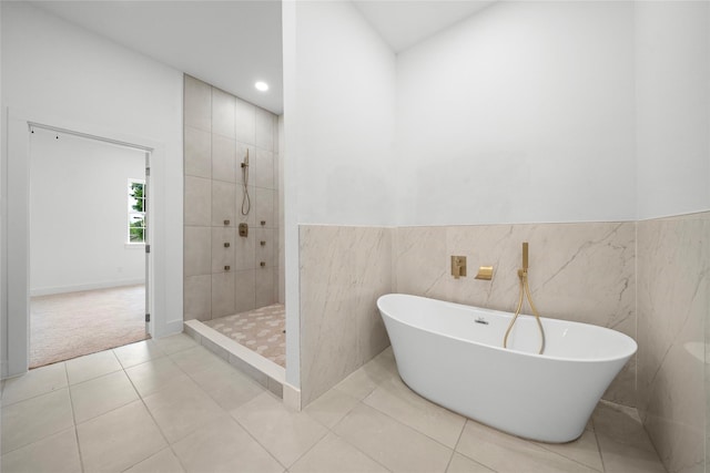 2012 Chew St, Houston, TX 77020 - full bathroom featuring a soaking tub, walk in shower, tile patterned floors, tile walls, and a wainscoted wall