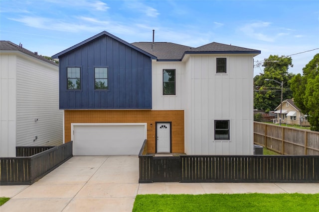 2012 Chew St, Houston, TX 77020 - view of front of home featuring a fenced front yard, concrete driveway, a garage, a shingled roof, and board and batten siding