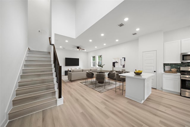 2012 Chew St, Houston, TX 77020 - living room with stairs, recessed lighting, light wood-style floors, and a ceiling fan