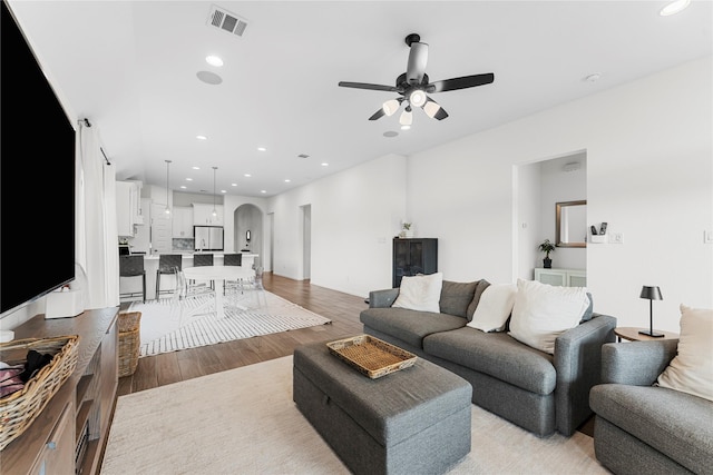 7202 Cordgrass Prairie Ln, Katy, TX 77493 - living area featuring arched walkways, light wood-style flooring, a ceiling fan, and recessed lighting