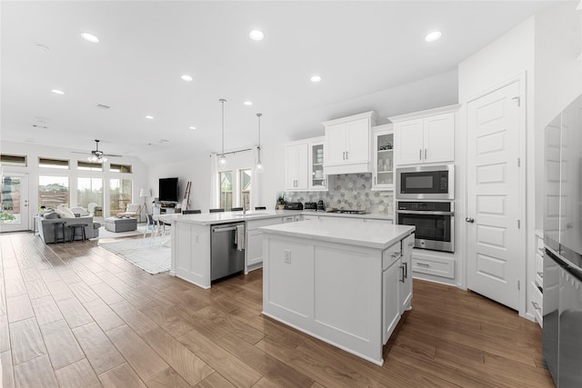 7202 Cordgrass Prairie Ln, Katy, TX 77493 - kitchen featuring a peninsula, open floor plan, appliances with stainless steel finishes, decorative backsplash, and white cabinets
