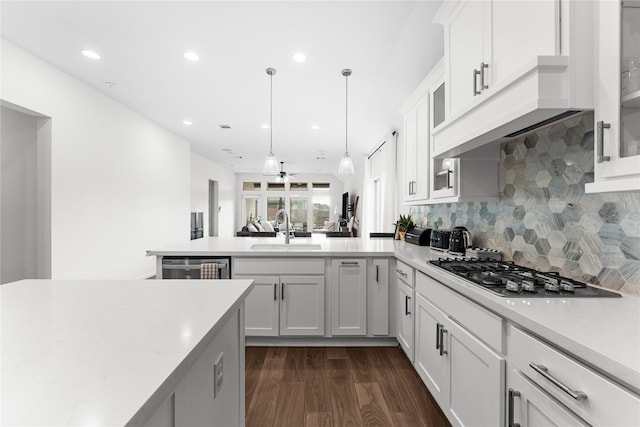 7202 Cordgrass Prairie Ln, Katy, TX 77493 - kitchen with a peninsula, light countertops, glass insert cabinets, decorative backsplash, and recessed lighting