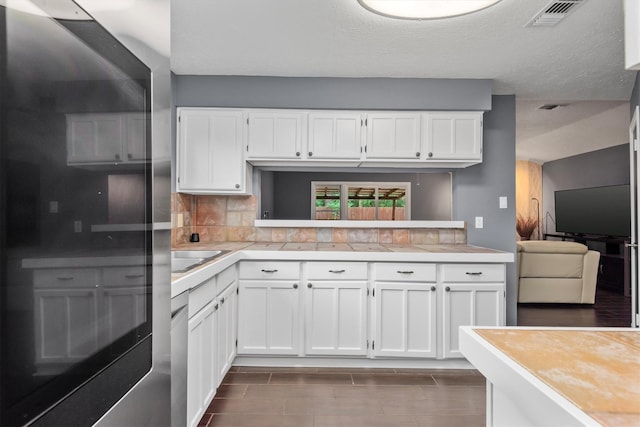 6510 Barrygate Dr, Spring, TX 77373 - kitchen featuring fridge, white cabinetry, backsplash, and a textured ceiling