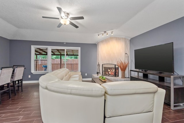 6510 Barrygate Dr, Spring, TX 77373 - living area with ceiling fan, a textured ceiling, dark wood-type flooring, and a fireplace