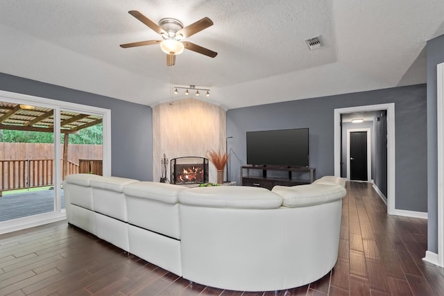 6510 Barrygate Dr, Spring, TX 77373 - living room with dark wood finished floors, a ceiling fan, vaulted ceiling, and a textured ceiling