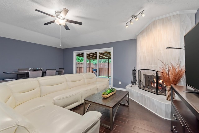 6510 Barrygate Dr, Spring, TX 77373 - living area featuring dark wood-type flooring, a tile fireplace, ceiling fan, and a textured ceiling