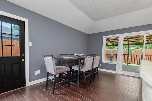 6510 Barrygate Dr, Spring, TX 77373 - dining room with dark wood-style flooring, vaulted ceiling, and a textured ceiling
