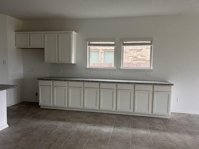 14217 Dream Rd, New Caney, TX 77357 - kitchen featuring white cabinets, tile patterned floors, and dark stone countertops