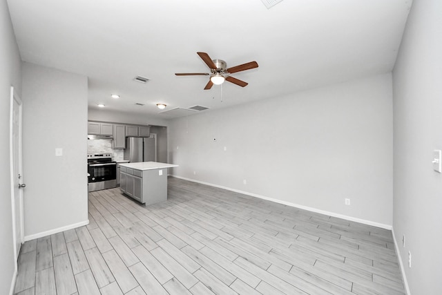 9805 Kerr, Houston, TX 77029 - kitchen with gray cabinets, a ceiling fan, light countertops, open floor plan, and stainless steel appliances