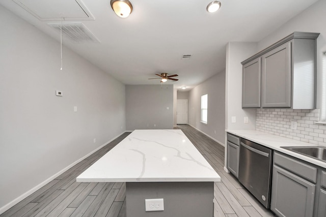 9805 Kerr, Houston, TX 77029 - kitchen with gray cabinetry, a kitchen island, light wood finished floors, dishwasher, and a ceiling fan
