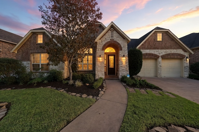 4118 Sage Brush Ct, Manvel, TX 77578 - french country inspired facade with stone siding, a yard, driveway, an attached garage, and brick siding