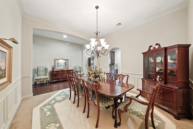 4118 Sage Brush Ct, Manvel, TX 77578 - dining room with a decorative wall, arched walkways, crown molding, wainscoting, and a chandelier
