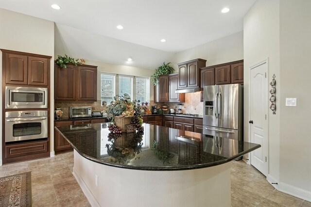 4118 Sage Brush Ct, Manvel, TX 77578 - kitchen featuring appliances with stainless steel finishes, decorative backsplash, dark brown cabinets, a spacious island, and recessed lighting