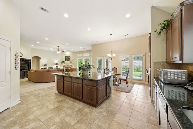 4118 Sage Brush Ct, Manvel, TX 77578 - kitchen with recessed lighting, dark stone countertops, a ceiling fan, a center island, and dark brown cabinets