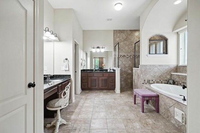 4118 Sage Brush Ct, Manvel, TX 77578 - bathroom with a tile shower, a bath, plenty of natural light, and two vanities