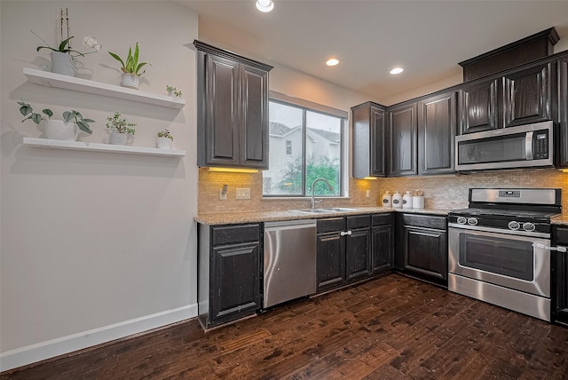 9027 Laverne Cres, Houston, TX 77080 - kitchen with appliances with stainless steel finishes, dark wood-type flooring, backsplash, recessed lighting, and light stone countertops