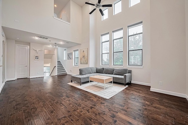 9027 Laverne Cres, Houston, TX 77080 - living room featuring ceiling fan, dark wood finished floors, stairs, and a towering ceiling