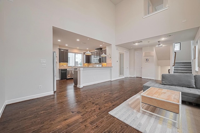 9027 Laverne Cres, Houston, TX 77080 - living room featuring dark wood-type flooring, stairs, and a towering ceiling