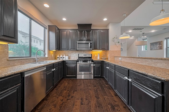 9027 Laverne Cres, Houston, TX 77080 - kitchen featuring appliances with stainless steel finishes, dark wood-style floors, tasteful backsplash, hanging light fixtures, and recessed lighting