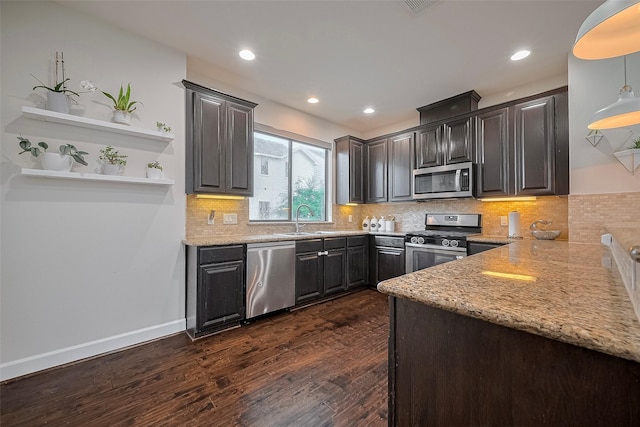 9027 Laverne Cres, Houston, TX 77080 - kitchen with dark wood-type flooring, stainless steel appliances, light stone counters, tasteful backsplash, and recessed lighting