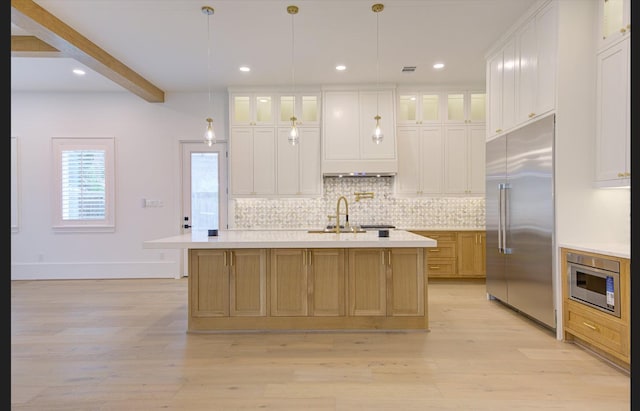 3909 Ella Blvd, Houston, TX 77018 - kitchen with built in appliances, tasteful backsplash, light countertops, light wood-type flooring, and an island with sink