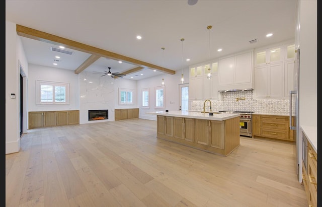 3909 Ella Blvd, Houston, TX 77018 - kitchen with light wood finished floors, beam ceiling, ceiling fan, tasteful backsplash, and a center island with sink