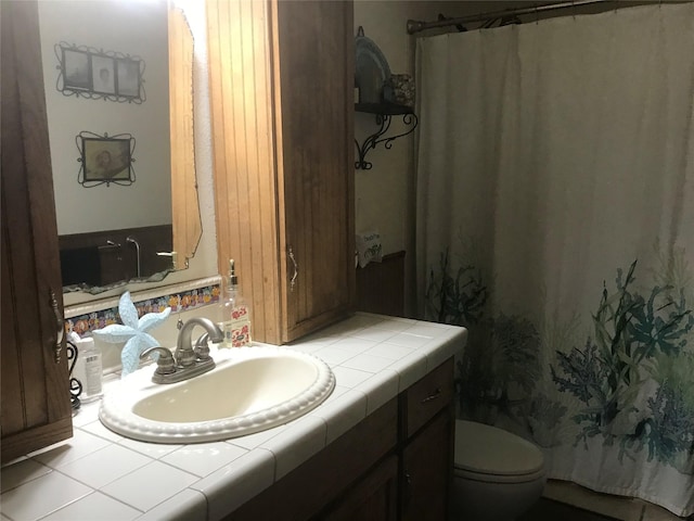 bathroom with toilet and large vanity