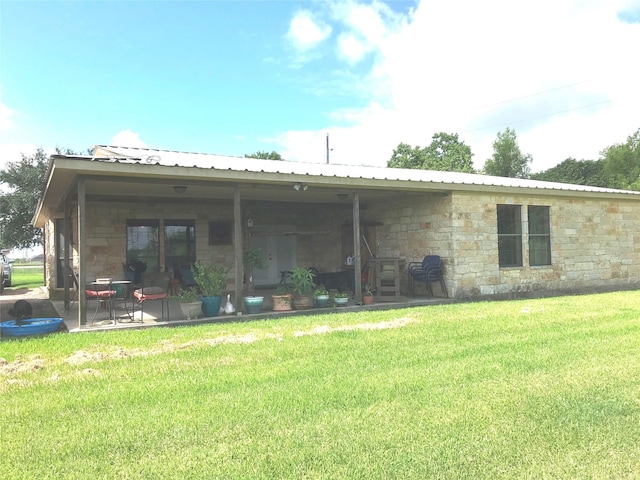 rear view of house with a patio and a yard